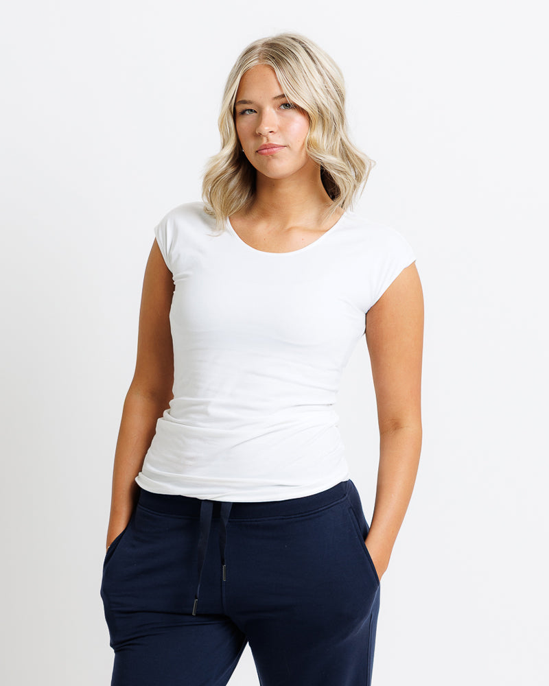 Woman wearing a white t-shirt and navy pants very comfortable