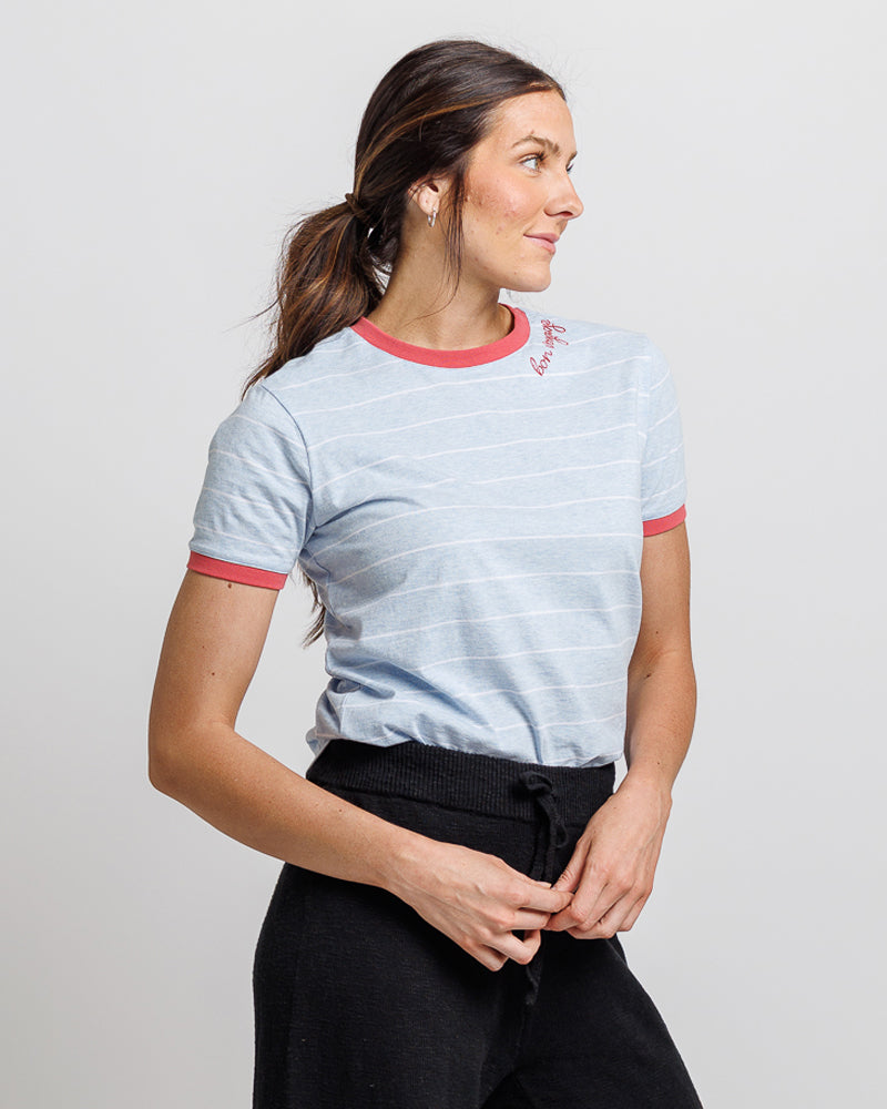 Woman wearing a light blue t-shirt with red trim