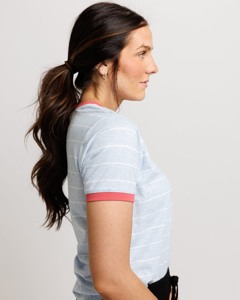 Woman wearing a light blue athletic shirt with red accents