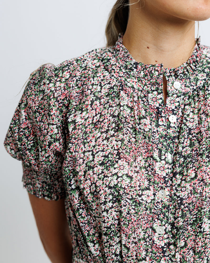 Floral patterned dress worn by a person on a plain background