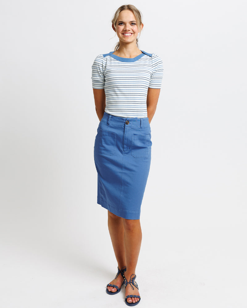 A lady sgowing her striped shirt and blue skirt for casual occasion
