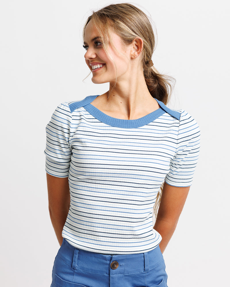 A young Lady  wearing a striped white and blue polo shirt