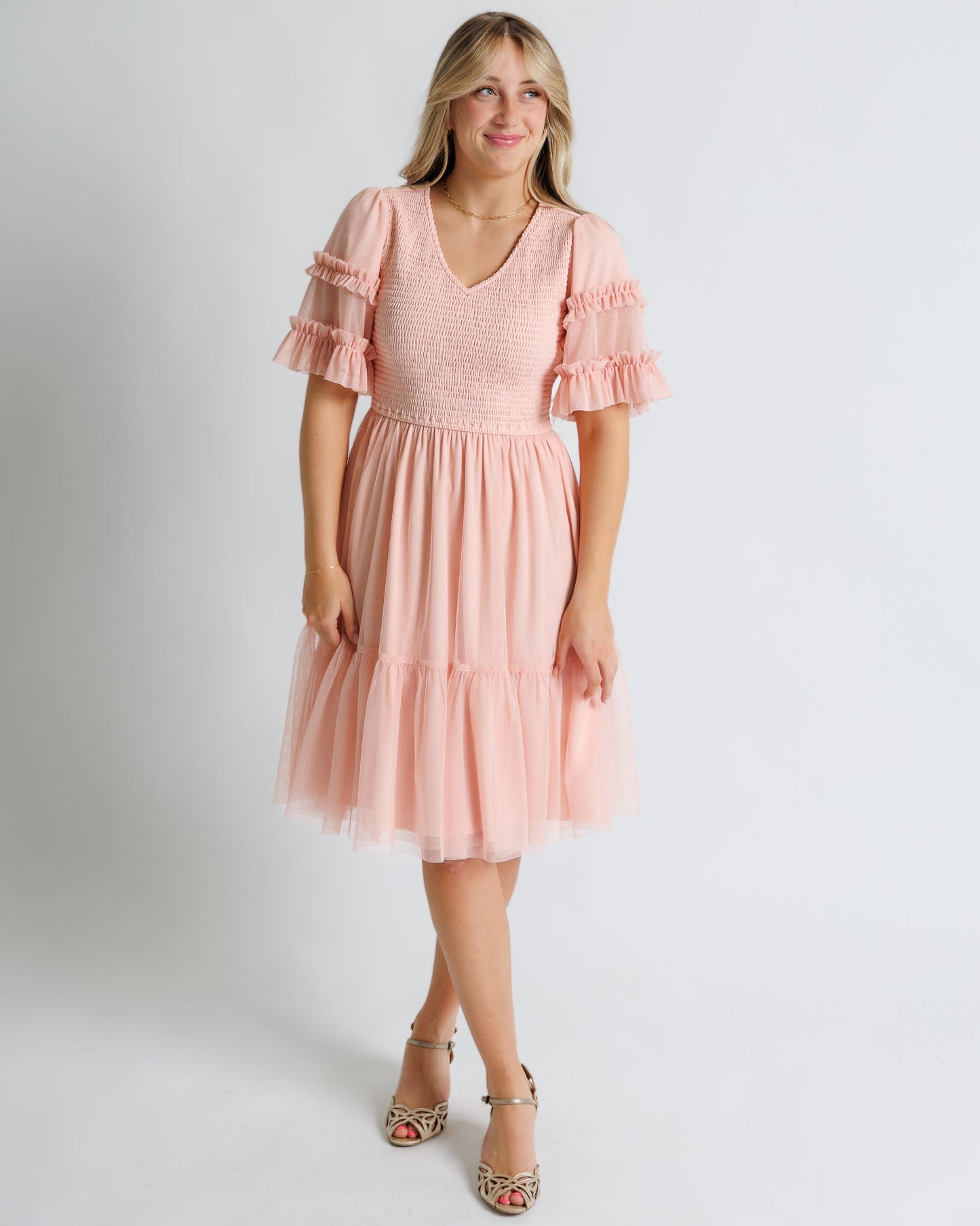Woman wearing a pink dress with ruffle sleeves