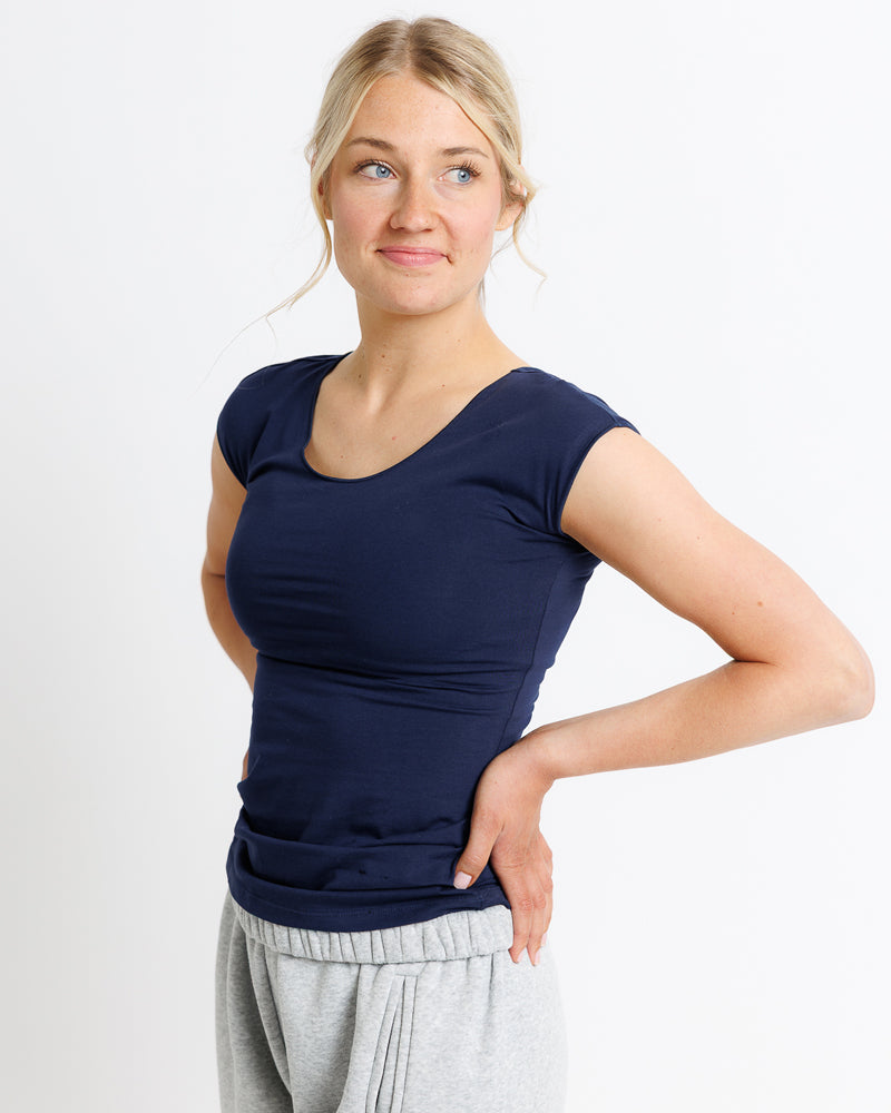 Woman wearing a navy blue top and gray pants