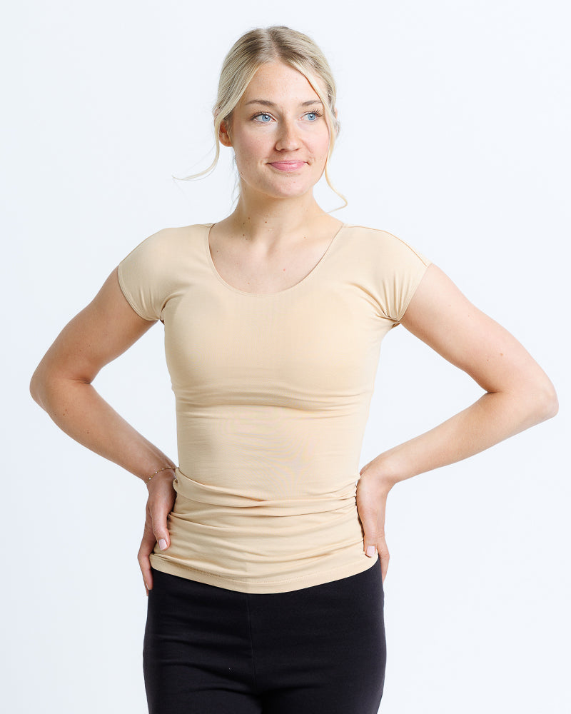 Woman wearing a beige t-shirt and a black pant.