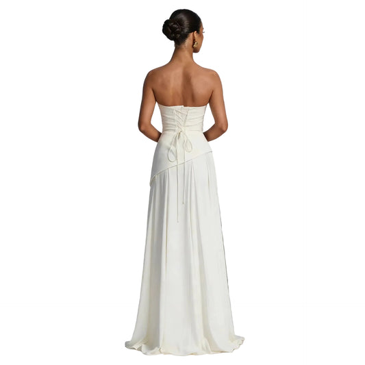Back view of white strapless gown showing lace-up corset closure and flowing asymmetric skirt Back view of white strapless gown showing lace-up corset closure and flowing asymmetric skirt