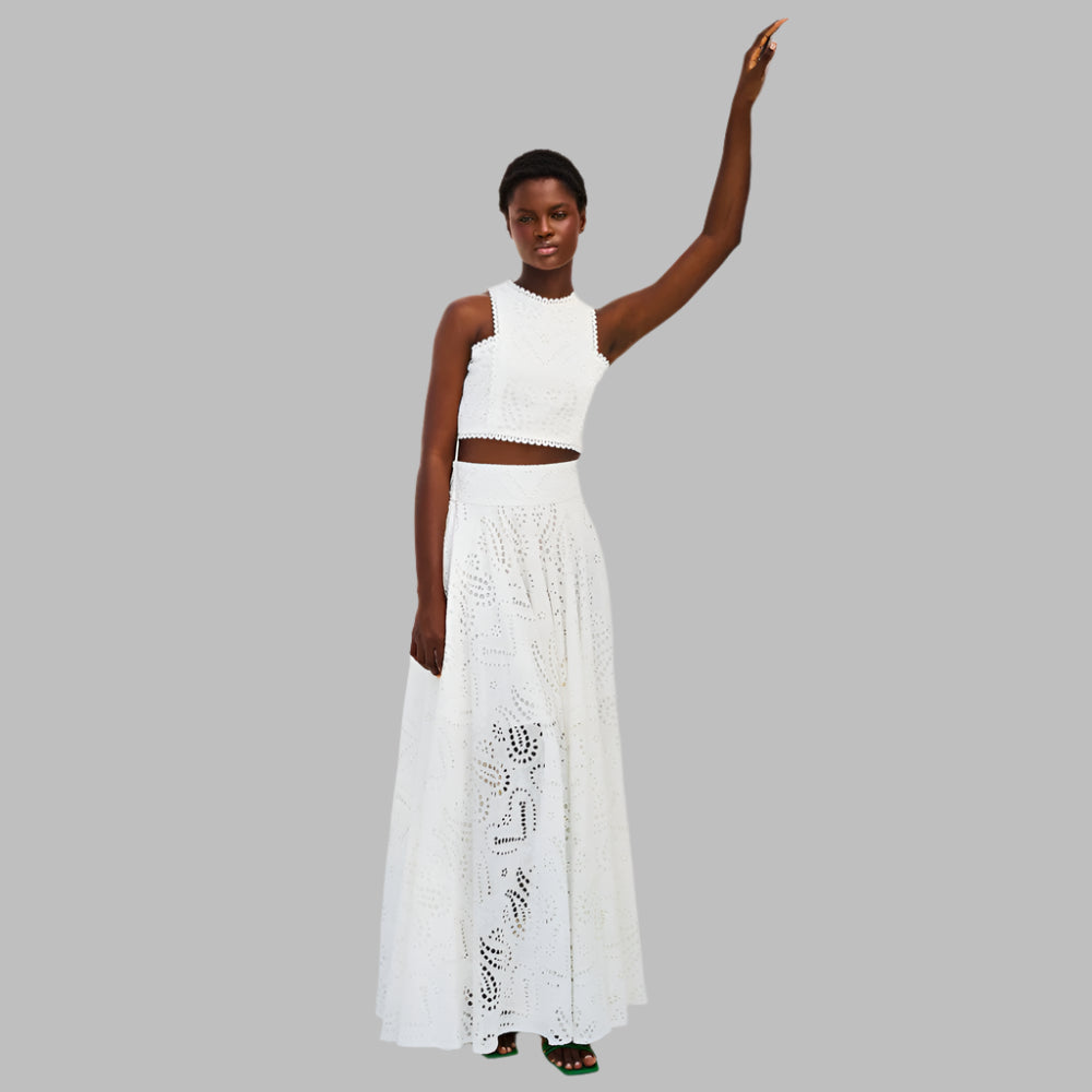 Woman wearing a white outfit with a lace skirt