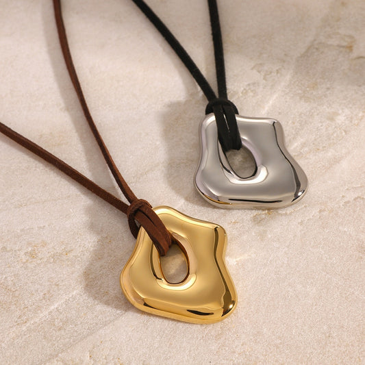 Two metallic pendants on leather cords  Two metallic pendants on leather cords