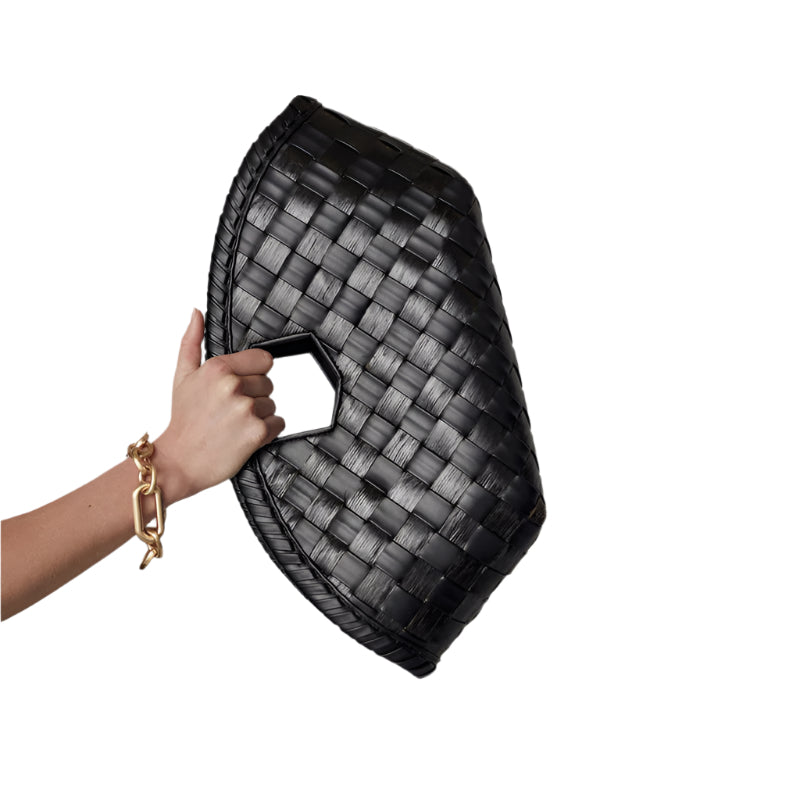 Black woven handbag held by a woman hand