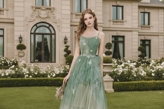 woman wearing a sage green glitter tulle A-line gown with butterfly appliqués and floral lace waist
woman wearing a sage green glitter tulle A-line gown with butterfly appliqués and floral lace waist