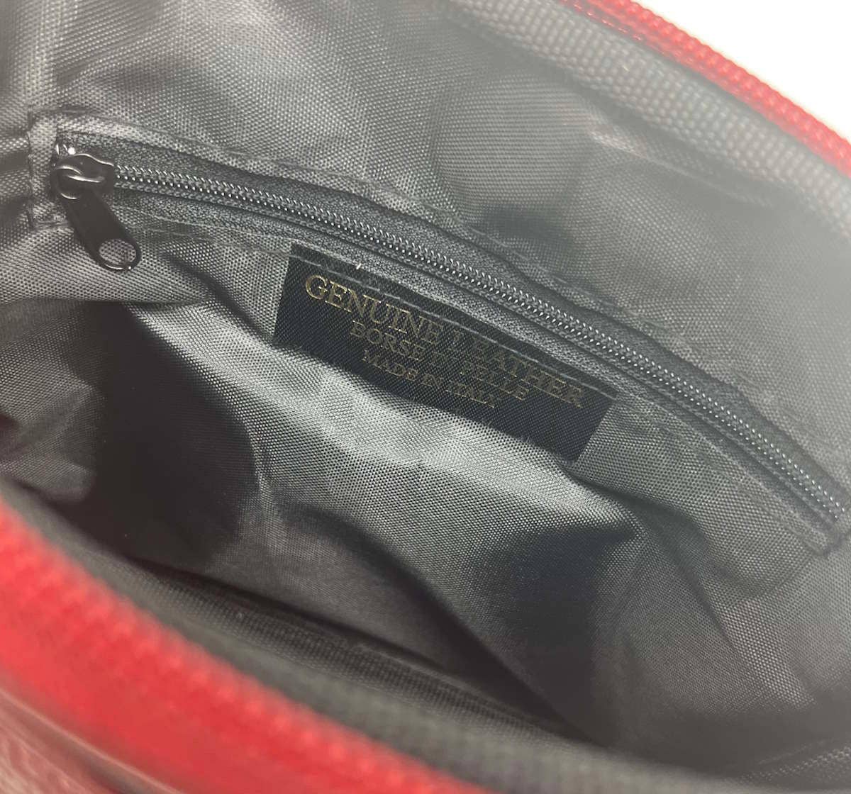 Gray interior of a bag with a visible label, showing 'Genuine Leather' branding.