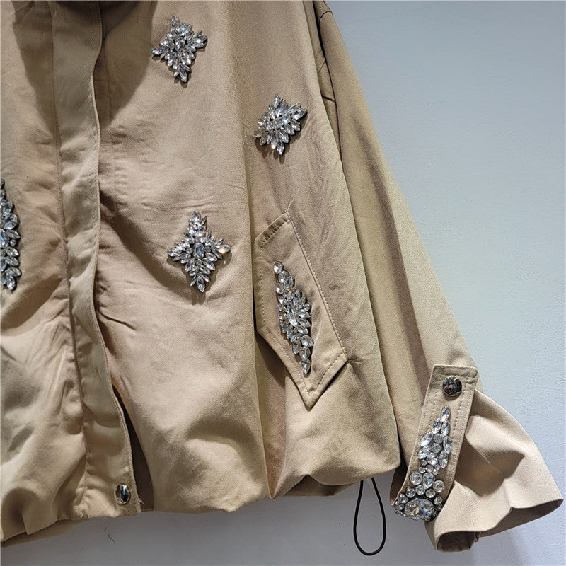 Beige jacket with decorative silver embellishments .