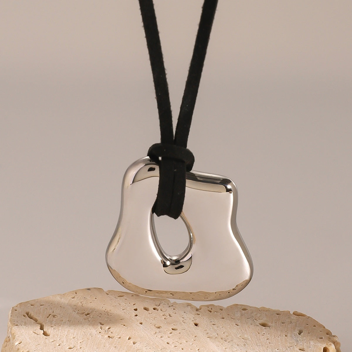 Silver pendant on a black cord