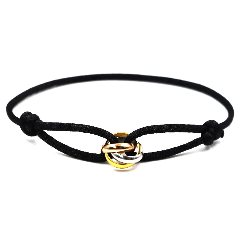 Black cord bracelet with a gold and silver interlocking ring charm