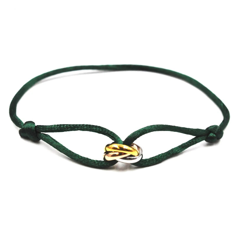 Green bracelet with a gold and silver on a white background