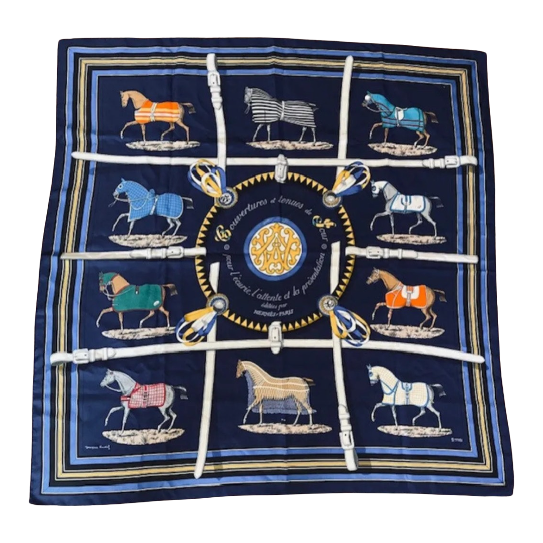 Navy blue silk scarf with horse illustrations and a central emblem on a white background