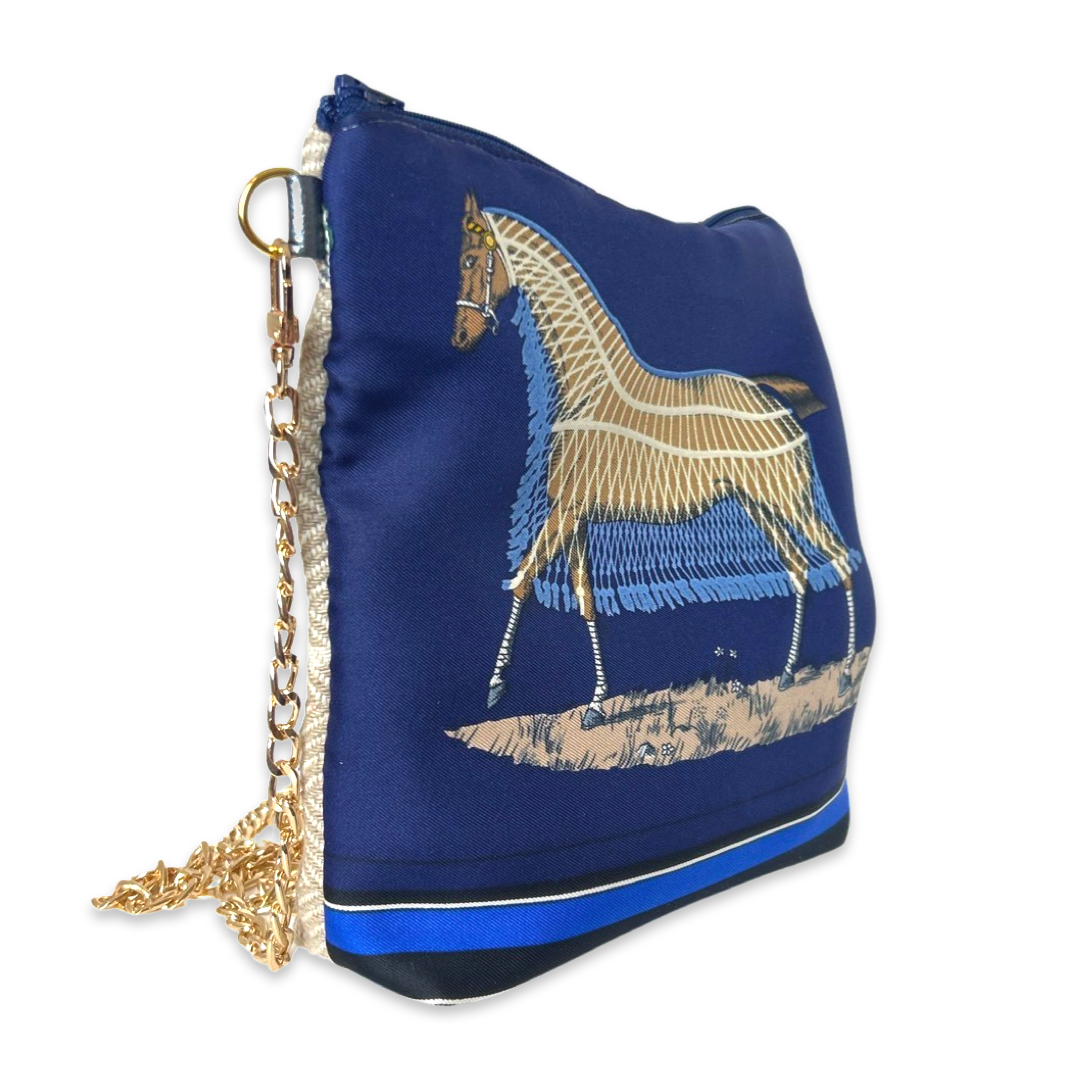 Blue handbag with embroidered horse design on a white background