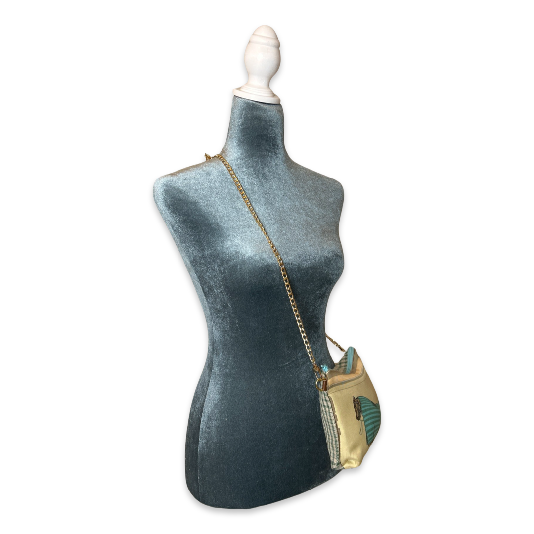 Mannequin wearing a gold crossbody bag with a white background