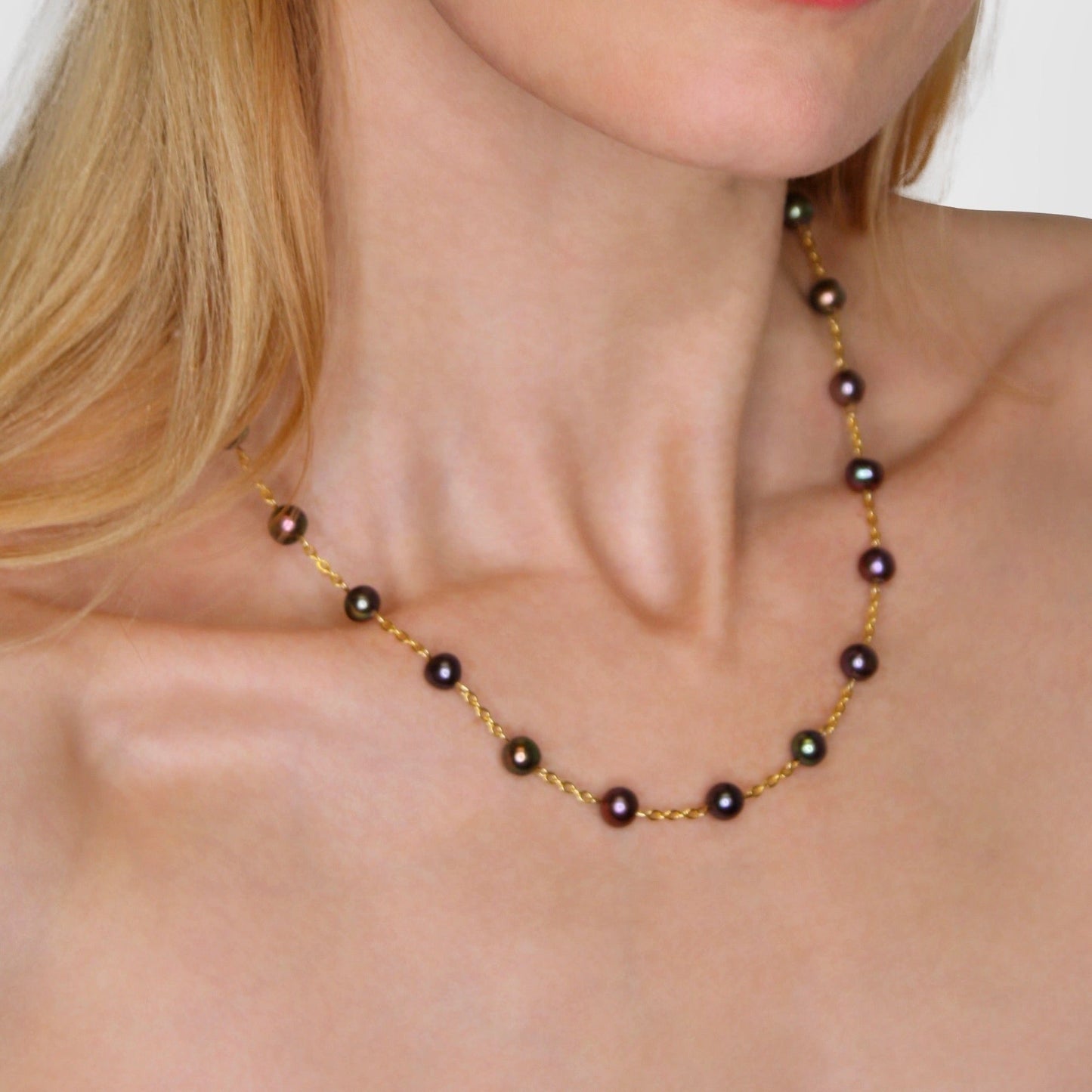 Pearl necklace on a model with a plain background