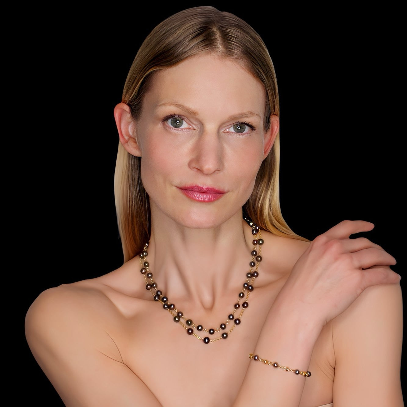 Woman wearing a necklace and bracelet on a black background