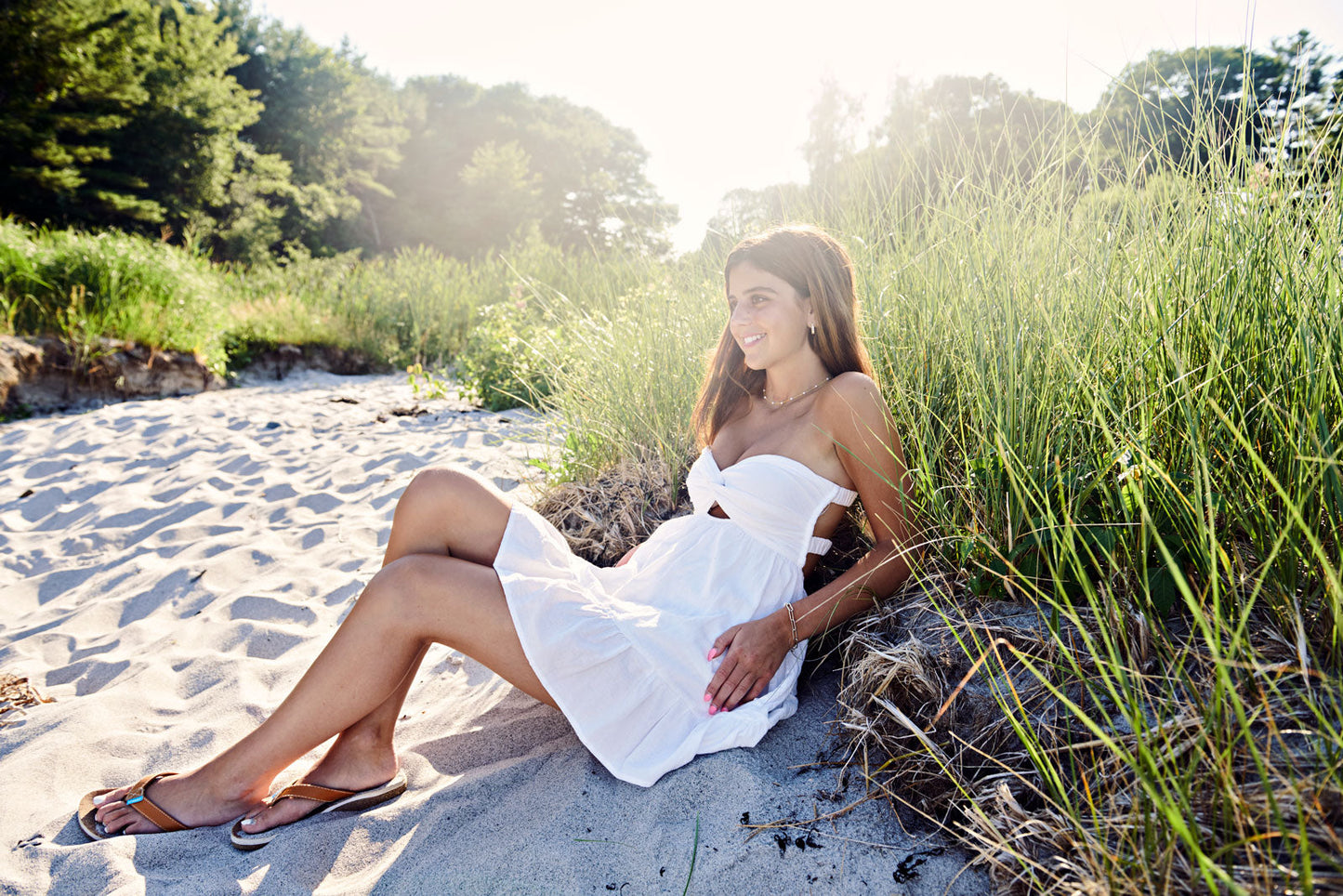 Woman in a white dress wearing a brown leather sandals