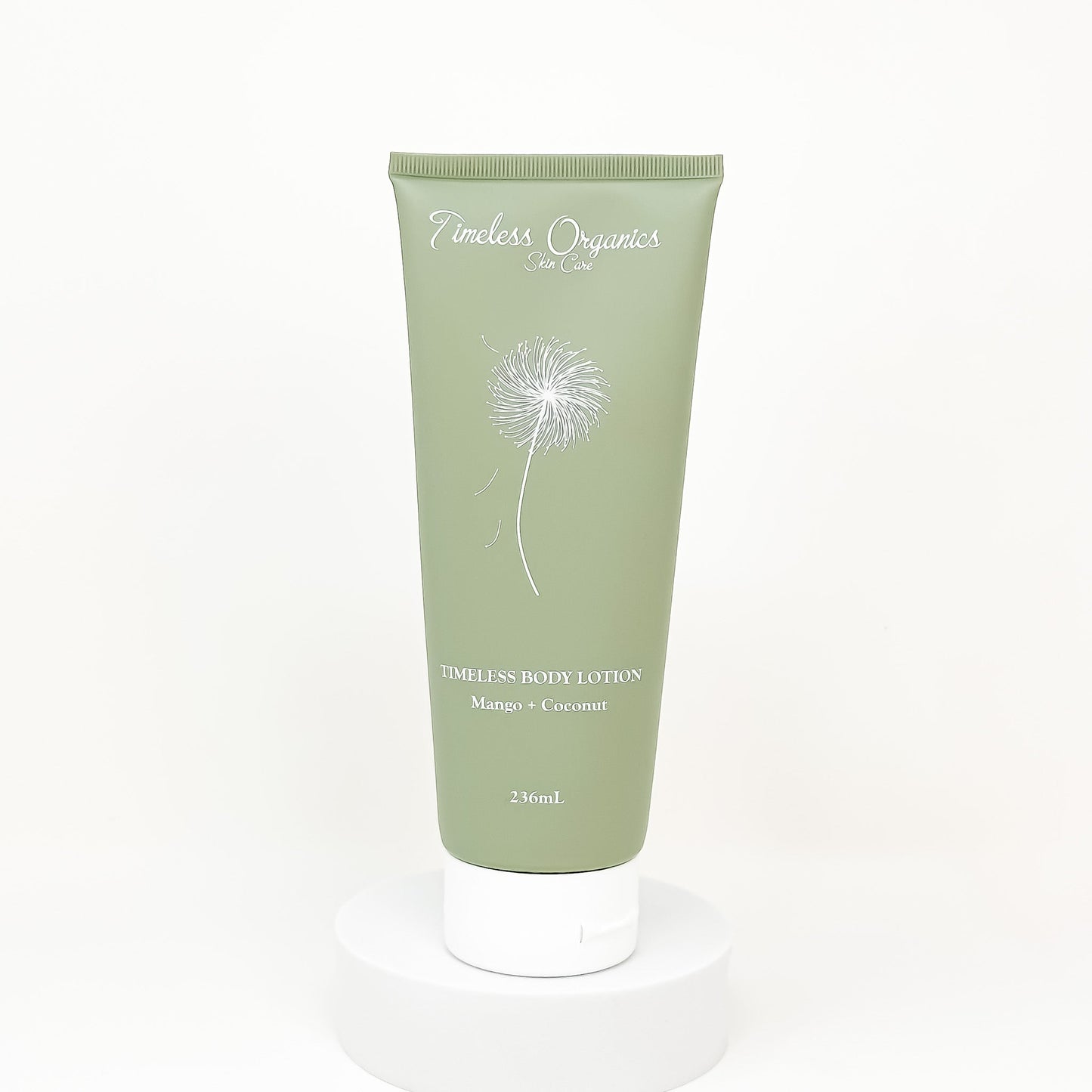 Green tube of body lotion with dandelion design on a white background