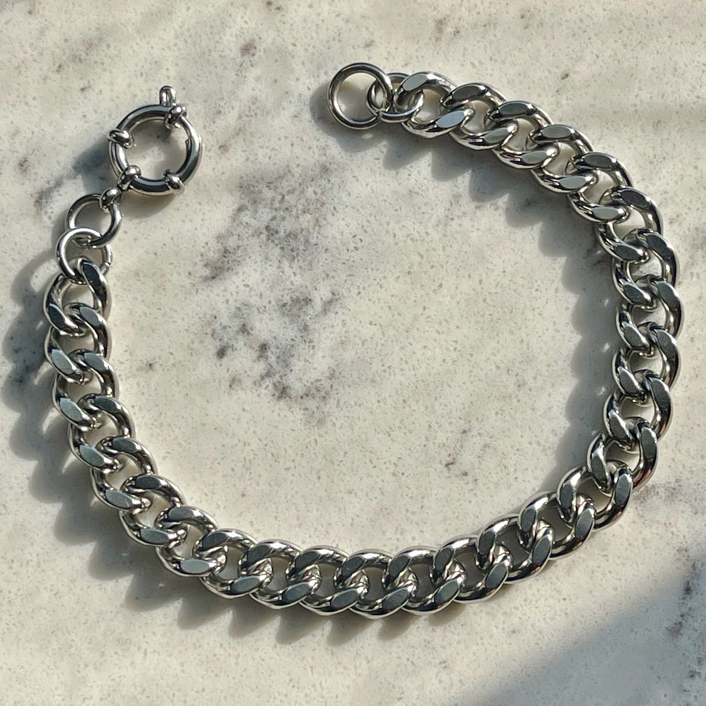 Silver chain bracelet on a textured surface