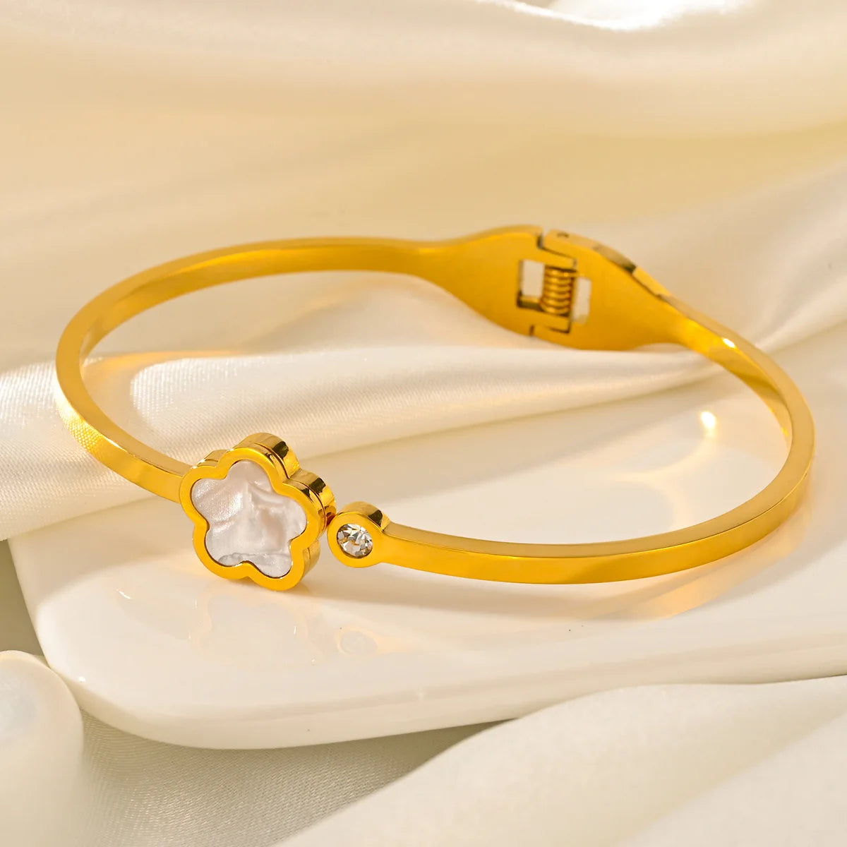 Gold bracelet with a white floral design