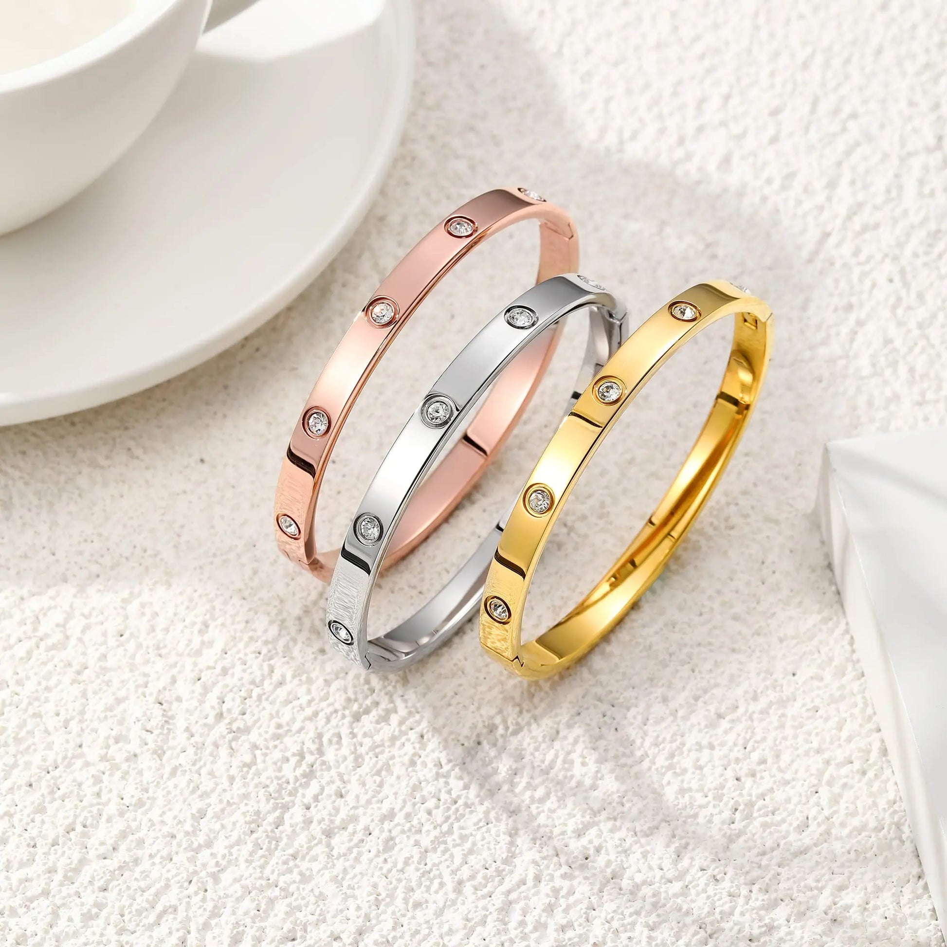 Three gold, silver, and rose gold bracelets