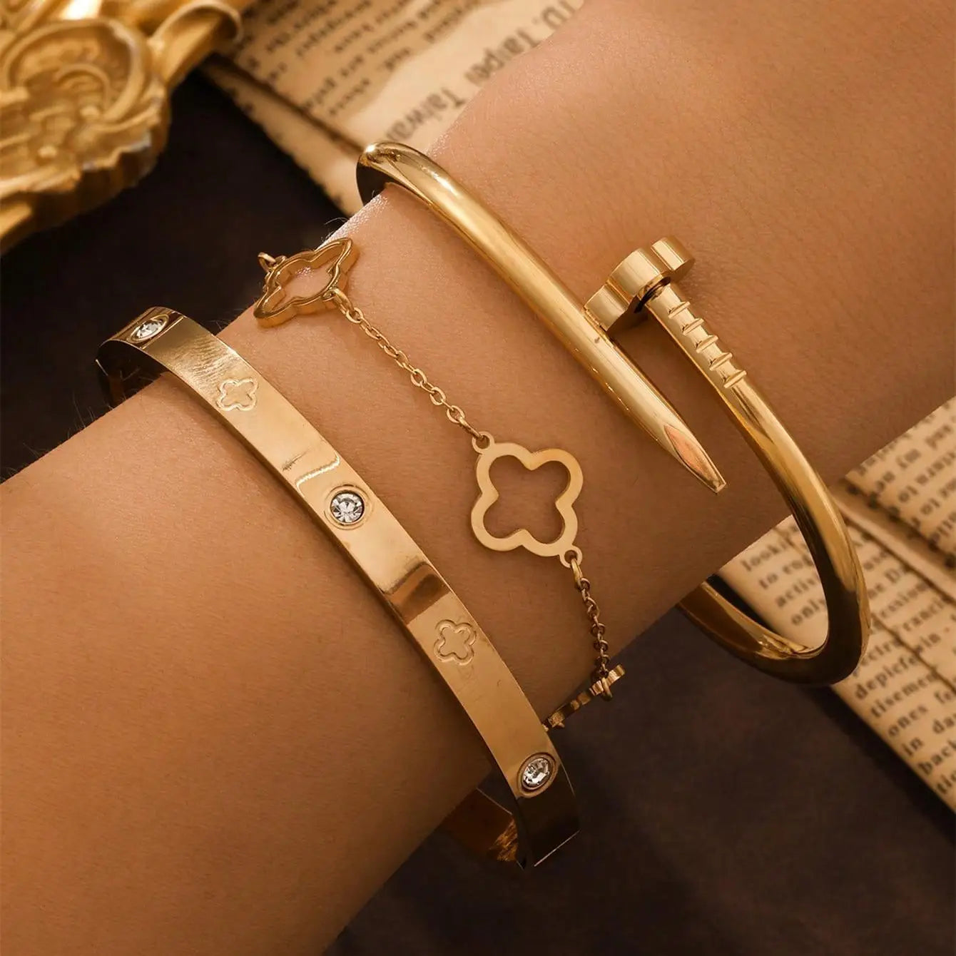 Three stainless steel bracelets with four‑leaf clover charms