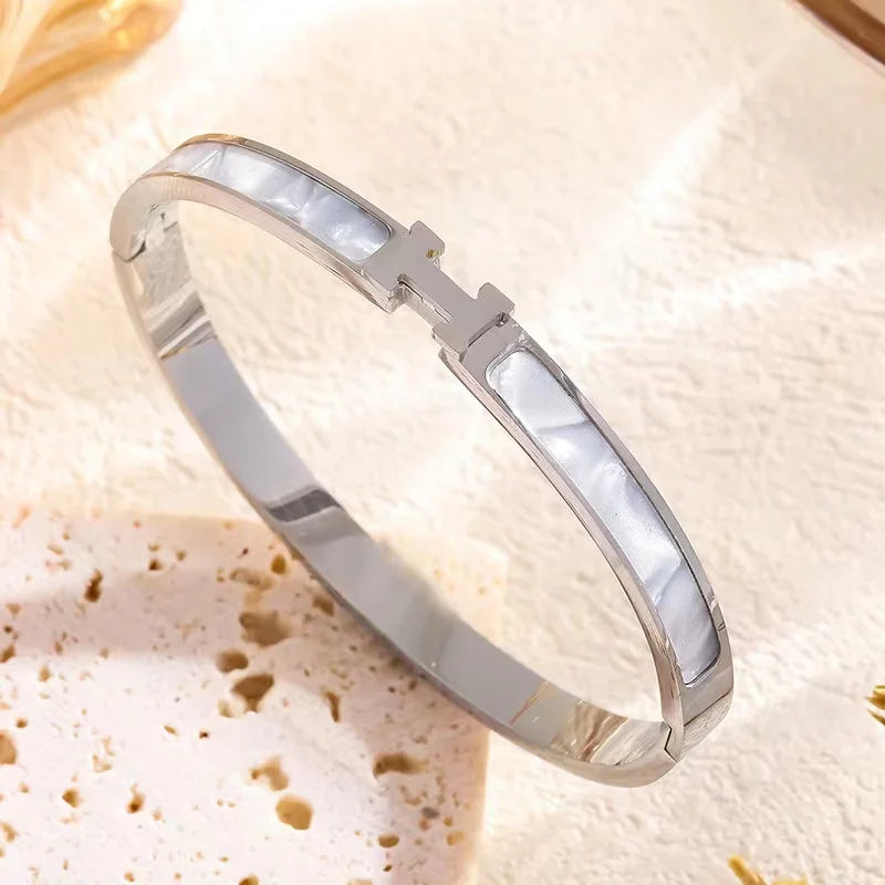 Silver Designer H bracelet with a white stone