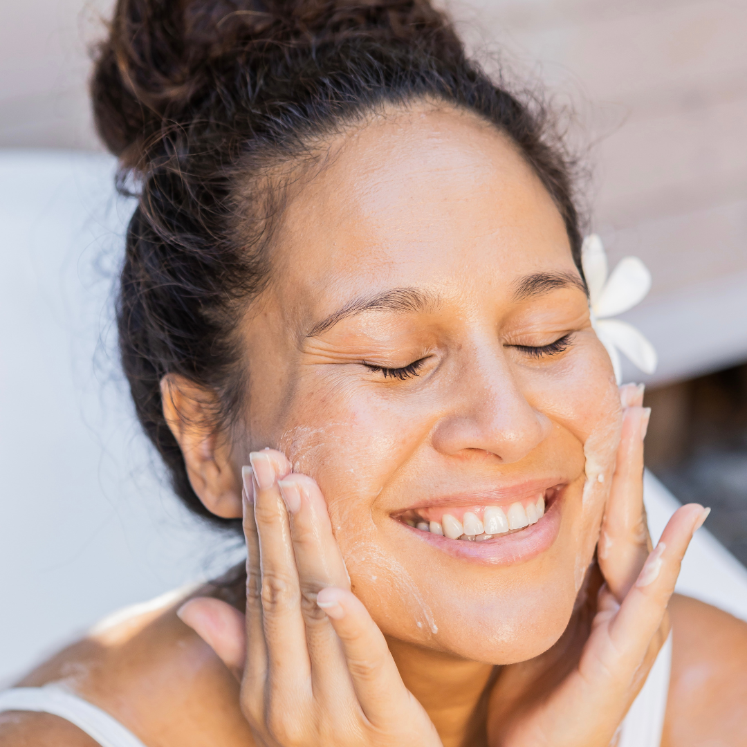 Woman applying cream to her face