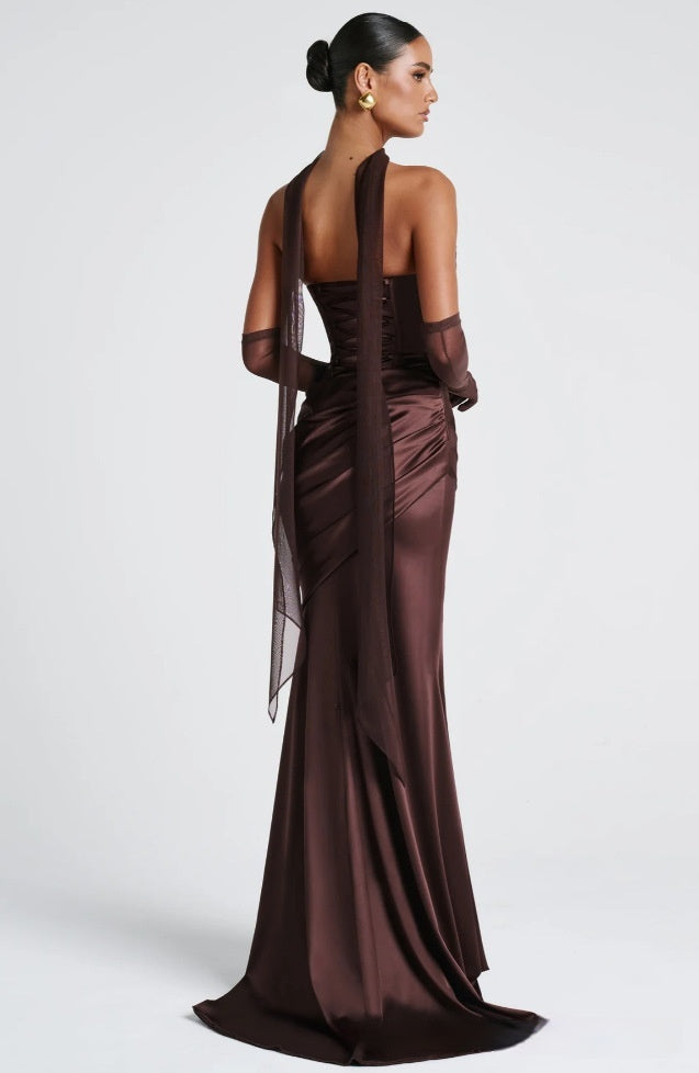 Woman wearing a brown evening gown with sheer sleeves