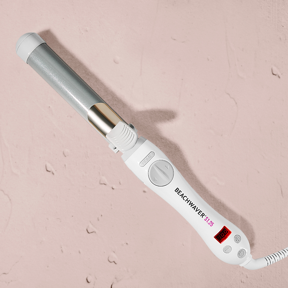 White hair straightener with digital display on a pink background