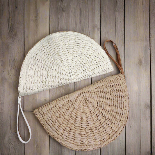 Half Moon Raffia Clutch in natural khaki color, showcasing its elegant curved shape and woven texture.  Half Moon Raffia Clutch in natural khaki color, showcasing its elegant curved shape and woven texture.