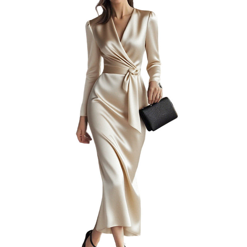 Woman wearing a beige long-sleeve dress holding a black clutch