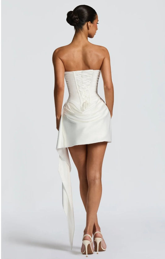 Strapless white satin fishtail dress showing sweetheart neckline and side drape detail.
Strapless white satin fishtail dress showing sweetheart neckline and side drape detail.