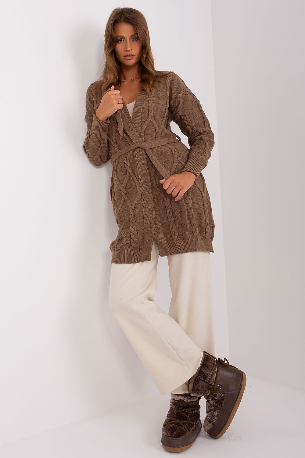 Woman layering brown cardigan over a casual outfit