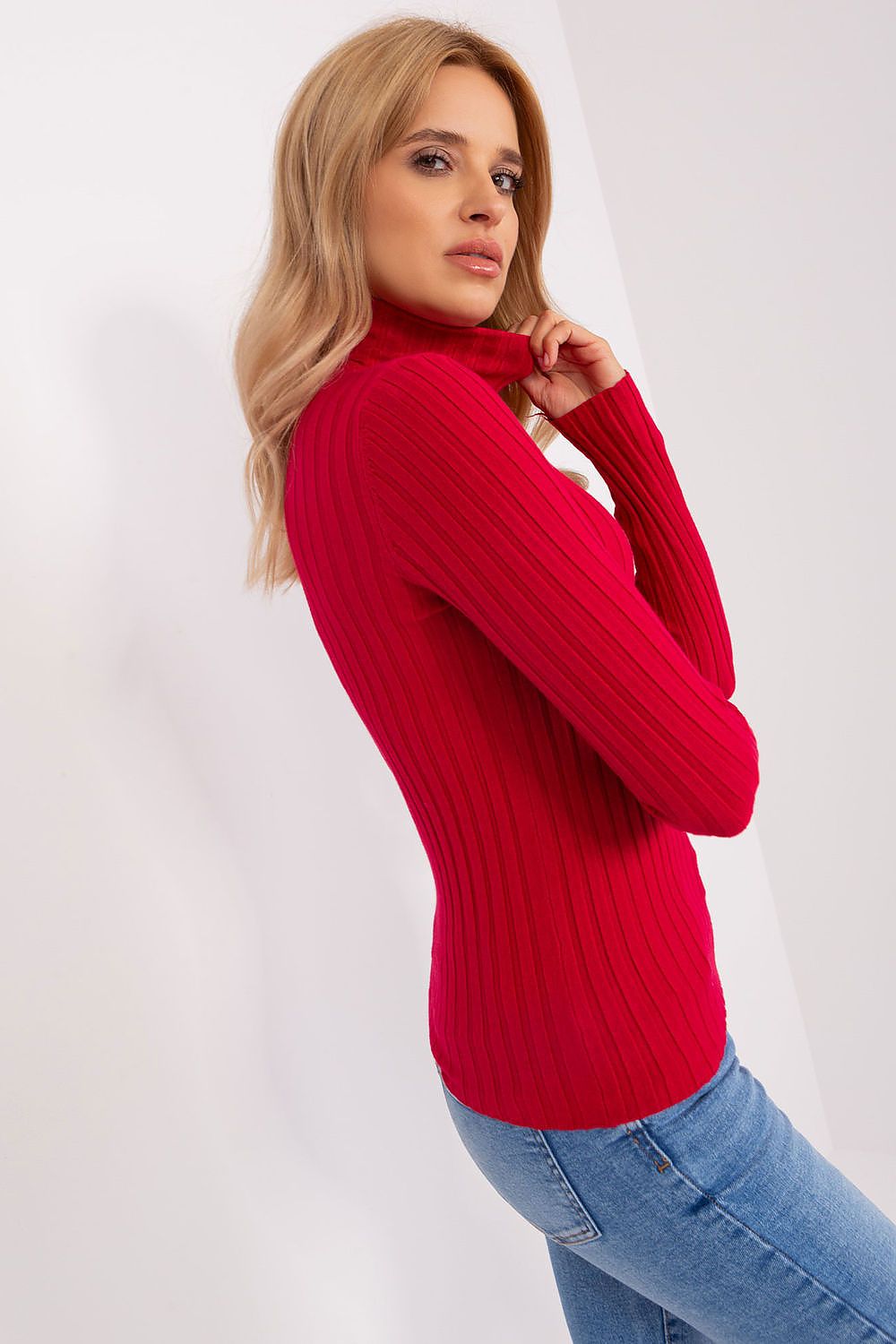 Woman wearing a red sweater and blue jeans