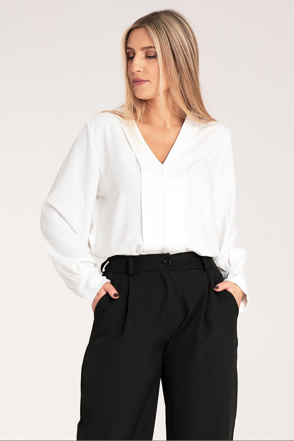 Woman wearing a high quality white blouse and black pants made in europe