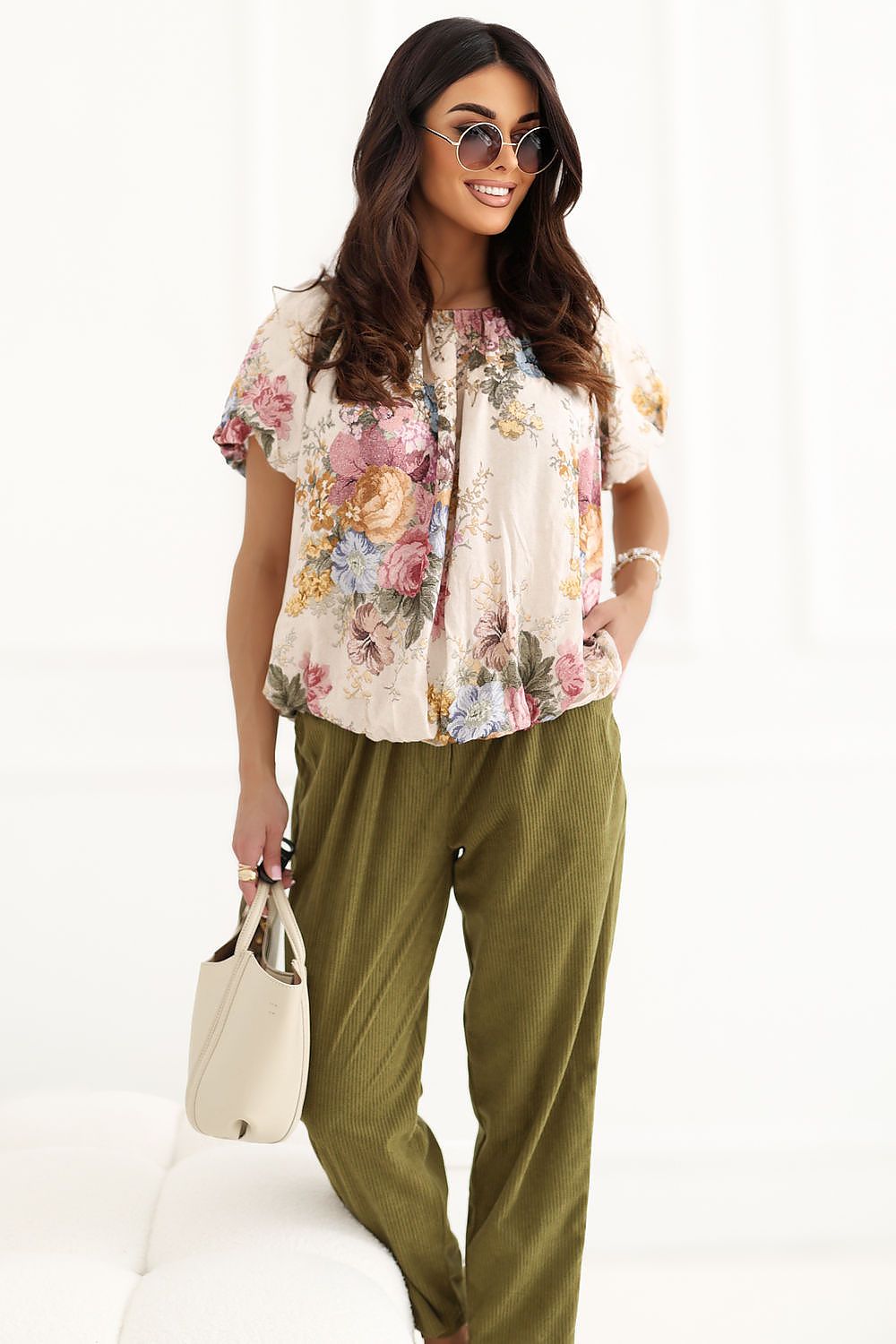Full length front view of model wearing floral puff sleeve blouse, off-shoulder neckline