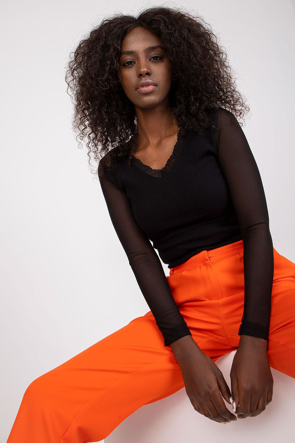 Woman dressed in trendy sheer sleeve red blouse for office