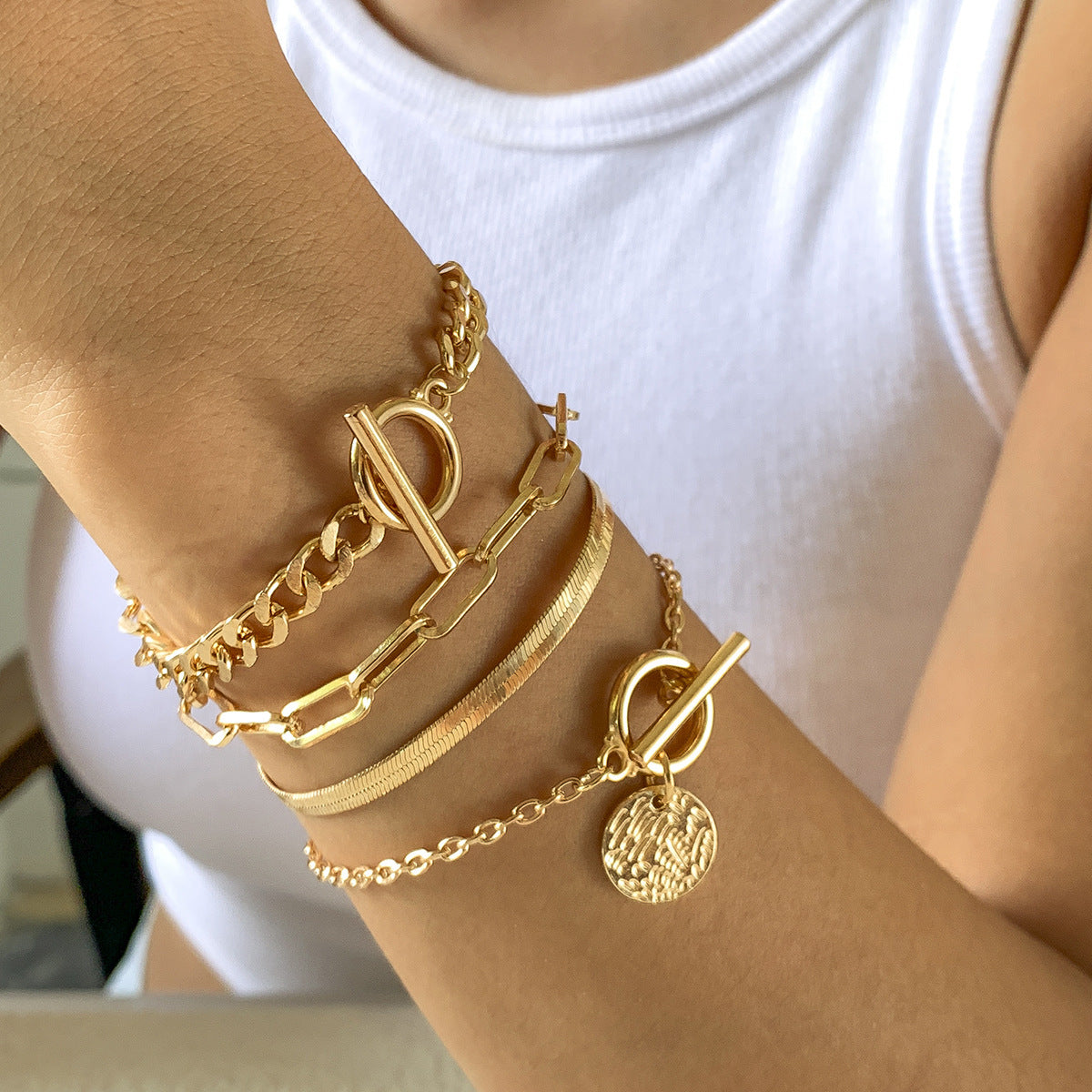Gold 4-bracelet set with chain and toggle clasps stacked on wrist