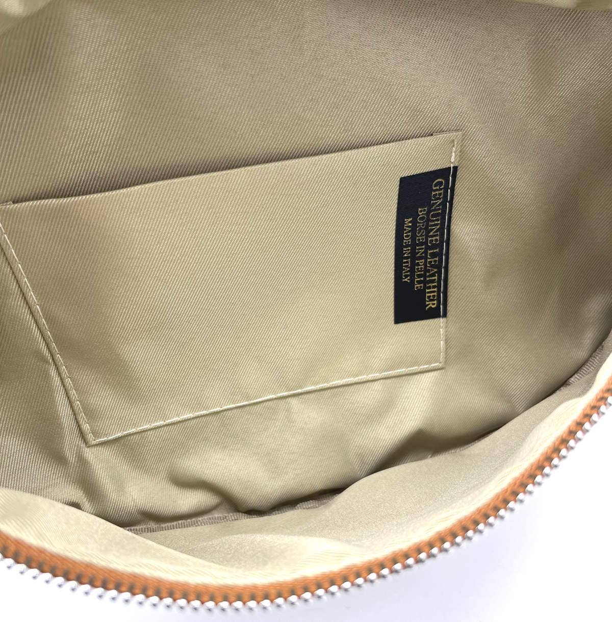 Close-up of a beige leather bag with a 'Genuine Leather' label.