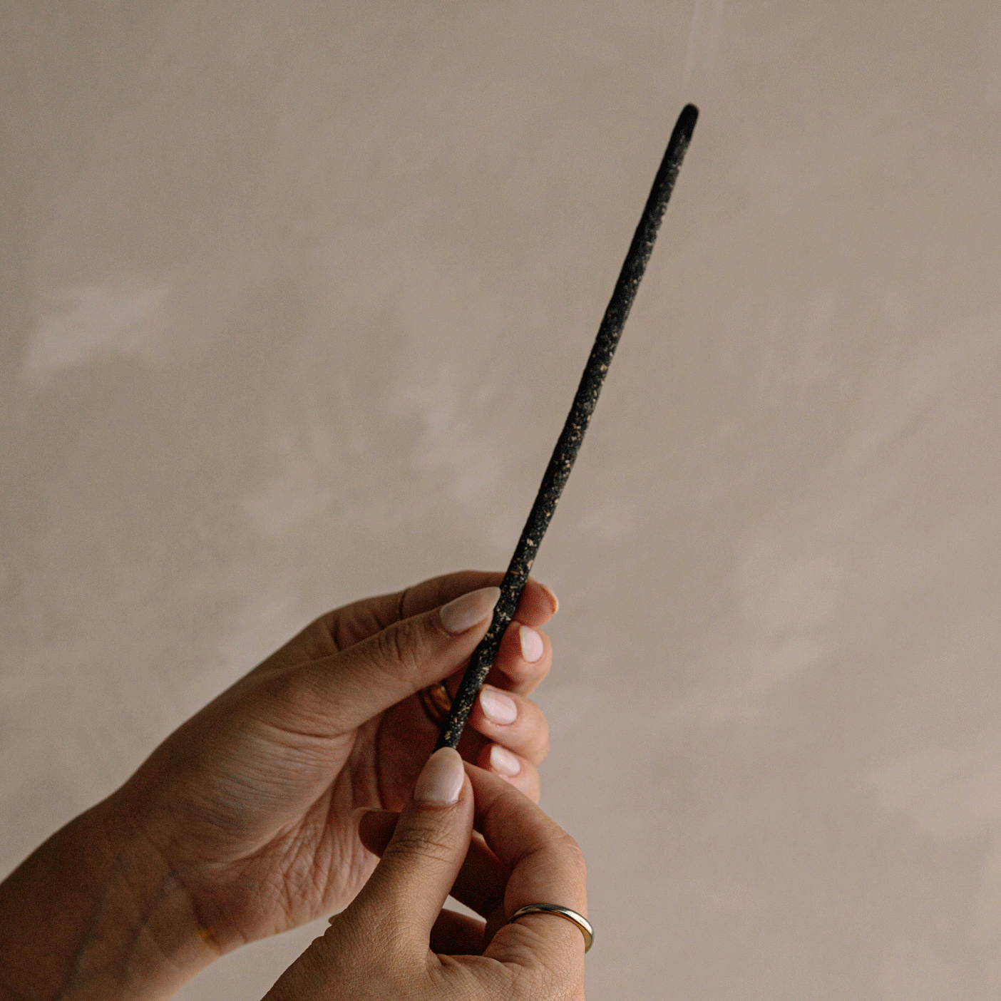 a lit incense stick of black copal