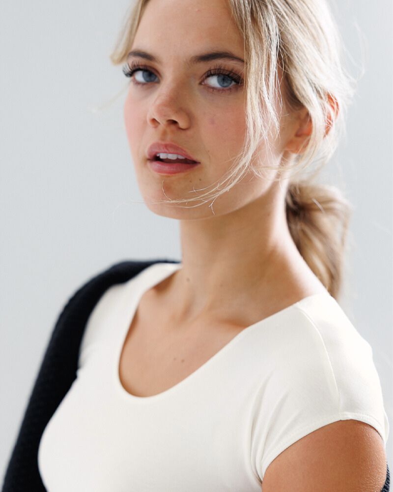 Woman with blonde hair wearing a white top