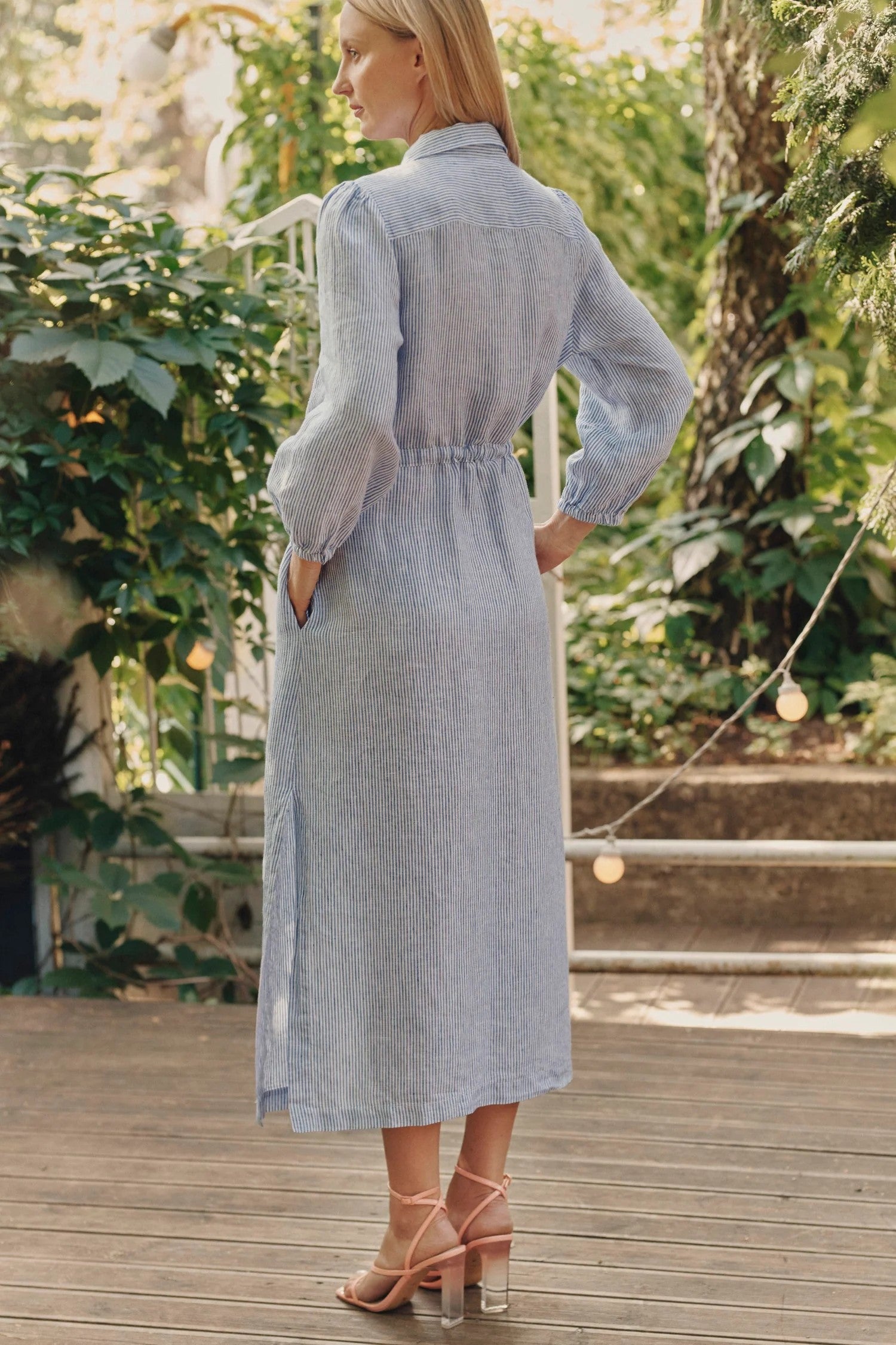 Back view of relaxed-fit linen dress with belt tied at waist.