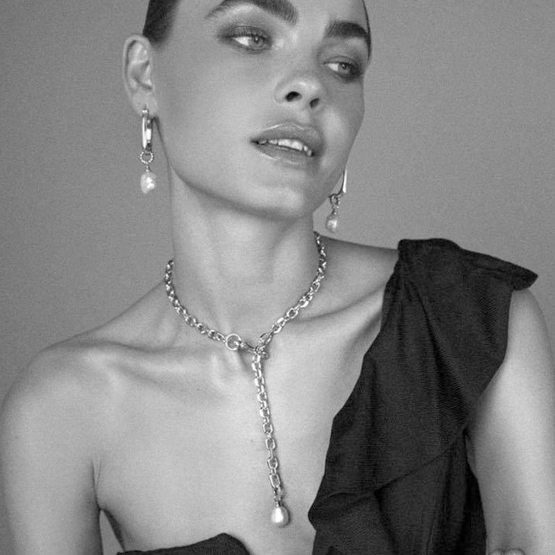 black and white picture of a woman with a set of pearl jewelry 