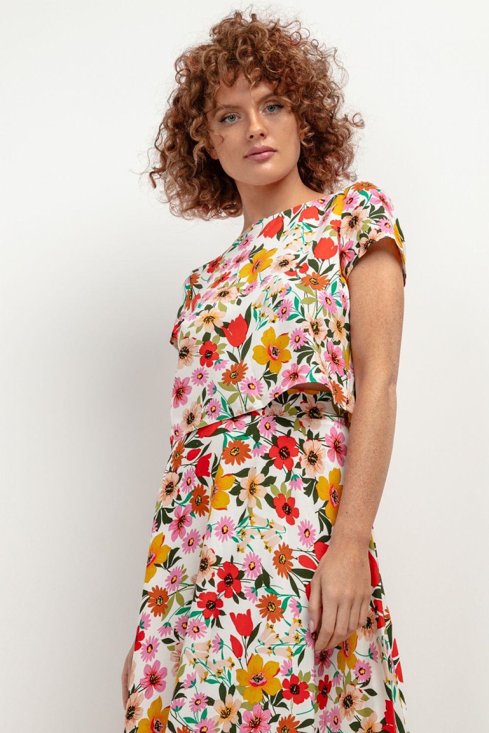 a beautiful elegant floral mediterranean outfit set on a woman with curly hair 