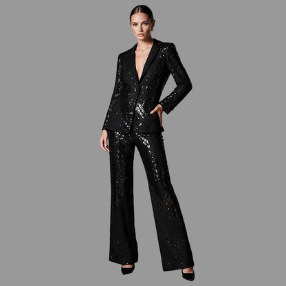 Front view of a black sequin lace pantsuit with satin lapels and wide-leg trousers on a model.

